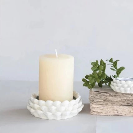 cream candle in cream pinecone dish