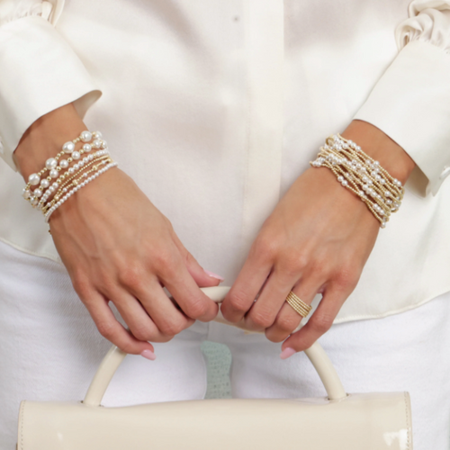 Pearl Bracelets on woman's hand with White Purse