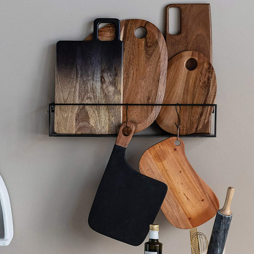 Various Suar Wood Cutting Boards hanging on wall