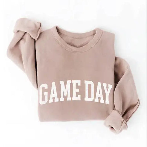 A dusty rose long-sleeve sweatshirt with 'GAME DAY' printed in white arched block letters across the chest, styled with rolled cuffs on a white background.