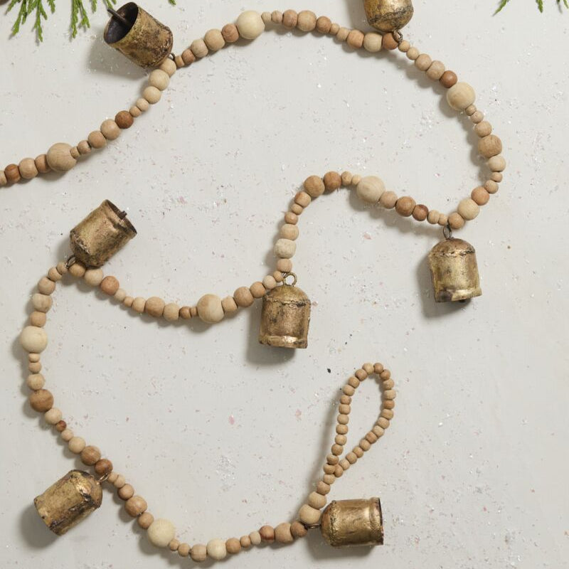 Decorative garland with wooden beads and metallic accents on a light background.