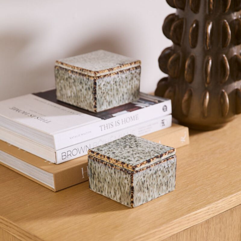 Decorative boxes and a vase on a wooden surface