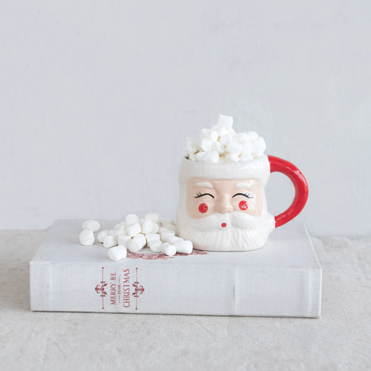 Santa Claus mug with marshmallows on a clear stand against a light gray background
