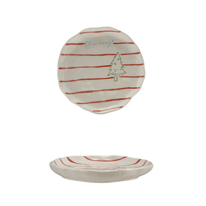A small round ceramic plate with a cream-colored glaze, decorated with thin red horizontal stripes and a simple green tree illustration, shown floating above a matching empty plate on a solid white background.