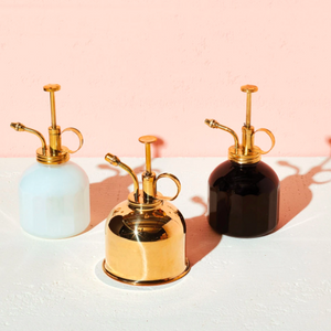 3 misters, a brass, a white glass with brass top, a black glass with copper top