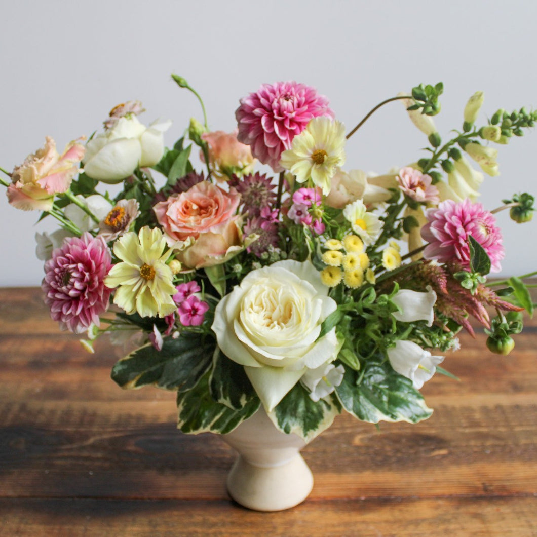 Large Fresh Designer Floral Arrangement with seasonal flowers in designer vase on table 