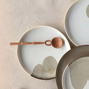 Hand-Carved Doussie Wood Spoon on various plates