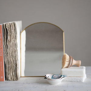 Brass Standing Arc Mirror on desk used as bookend