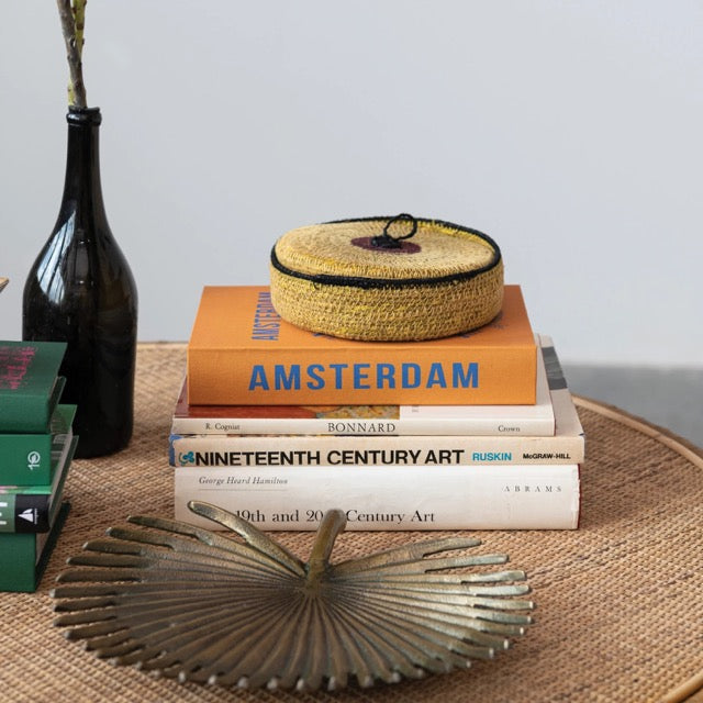 Brass Palm Frond Tray on coffee table with various books and vases