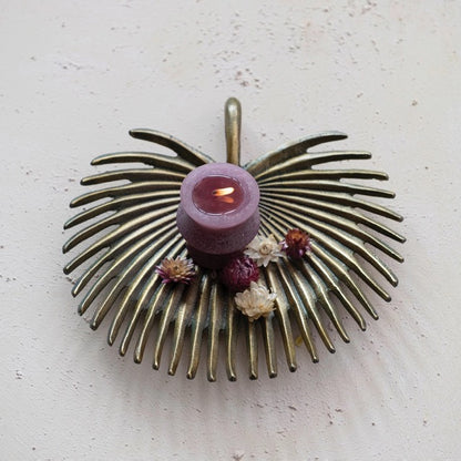 Brass Palm Frond Tray holding purple candle and dry flowers
