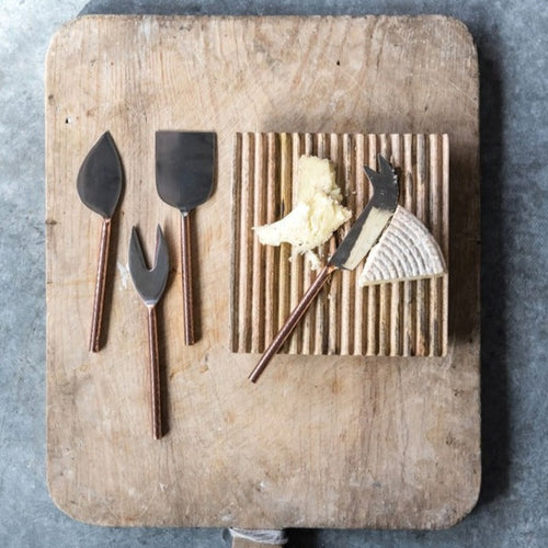 A Set of 4 Cheese knives that are stainless steel with a hammered copper finish handles. A Beautiful addition to any charcuterie board!